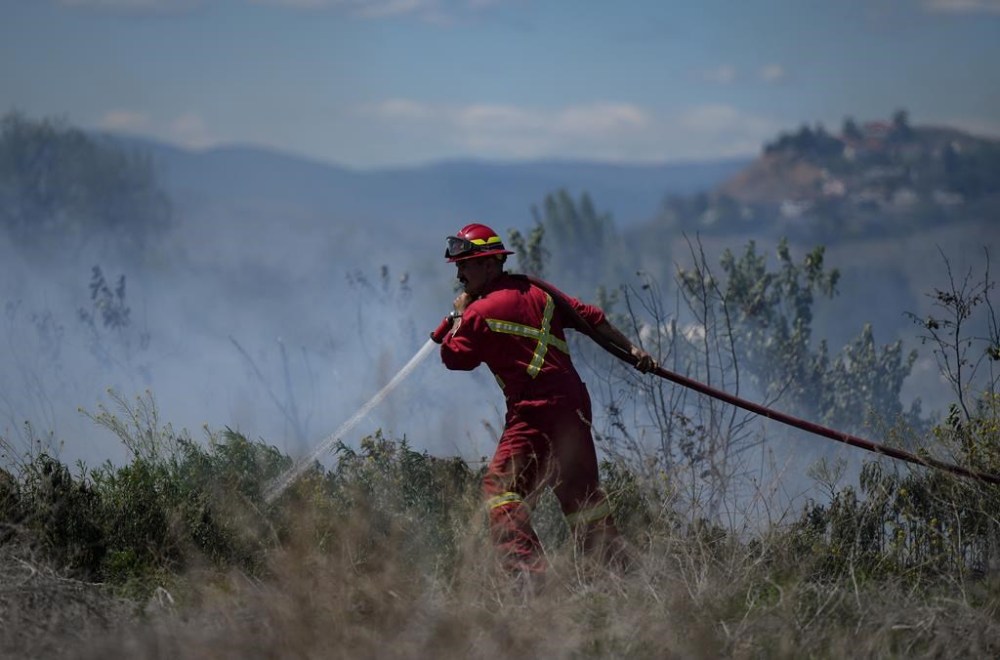 Parts of a British Columbia Interior community is under tactical evacuation due to the threat of a nearby wildfire. A firefighter directs water on a grass fire burning in Kamloops, B.C., Monday, June 5, 2023. THE CANADIAN PRESS/Darryl Dyck