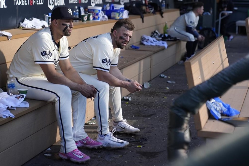Minnesota Twins' Royce Lewis, left, and Kyle Farmer sit in the dugout after their loss to the Baltimore Orioles of a baseball game Sunday, Sept. 29, 2024, in Minneapolis. (AP Photo/Abbie Parr)