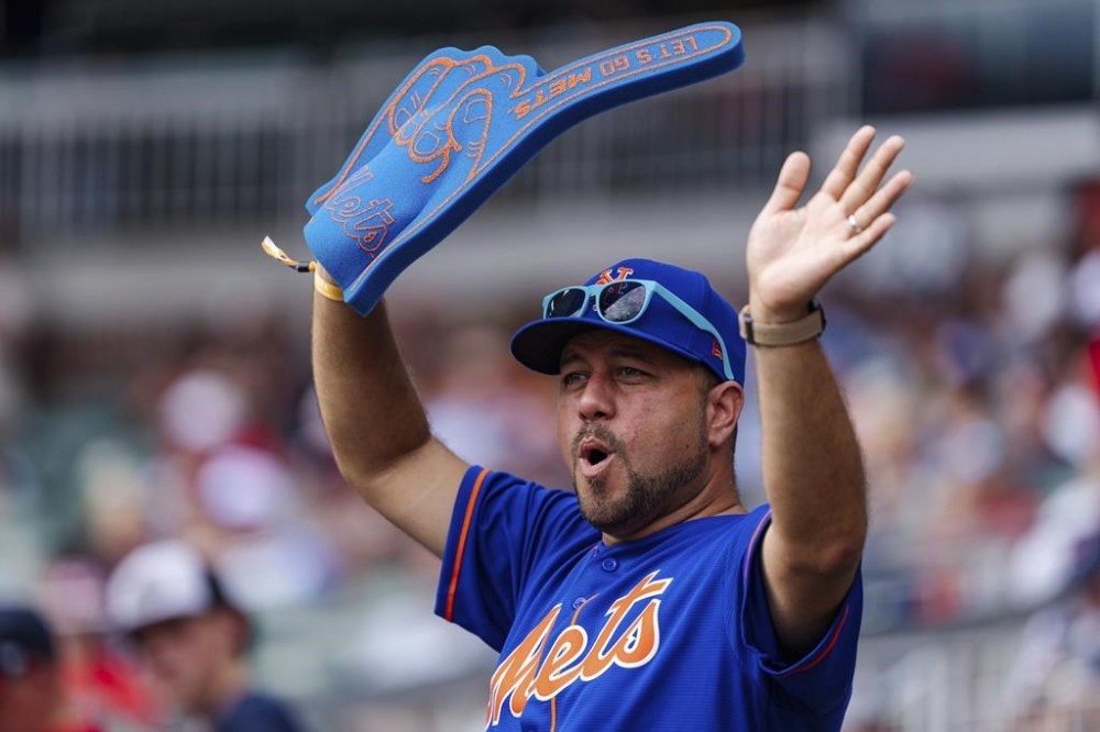 A fan dances in the stands during a rally in the eighth inning of a baseball game between the New York Mets and the Atlanta Braves, Monday, Sept. 30, 2024, in Atlanta. (AP Photo/Jason Allen)