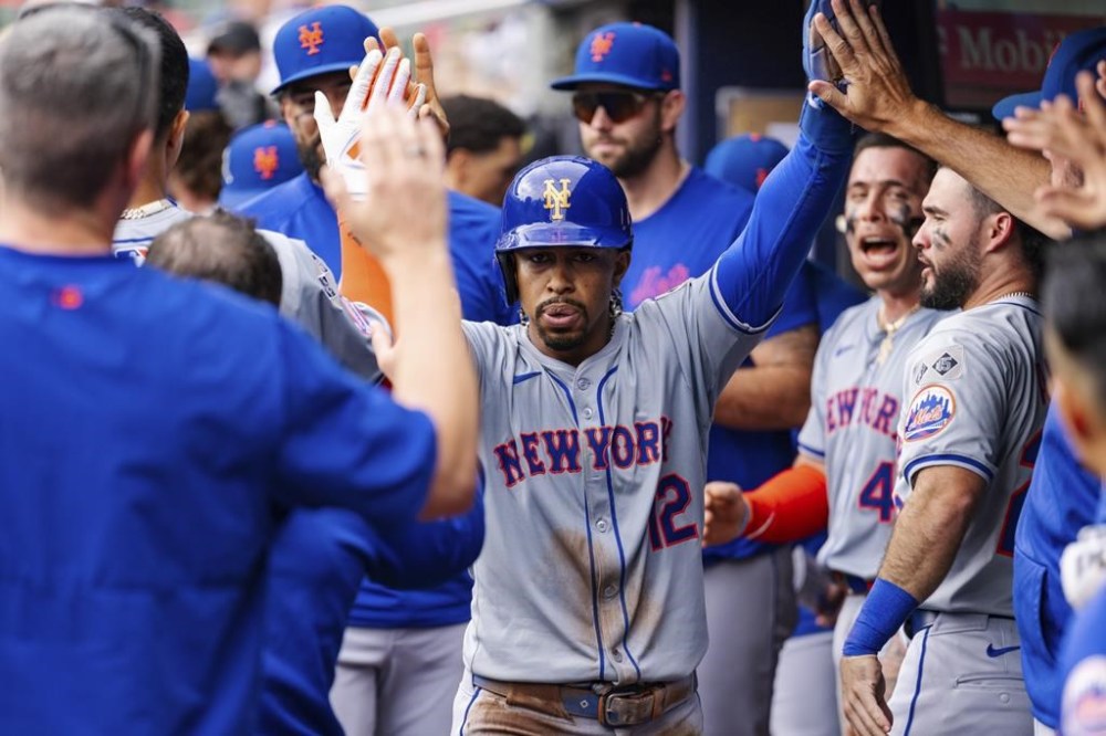New York Mets' Francisco Lindor celebrates in the dugout after scoring in the eighth inning of a baseball game against the Atlanta Braves, Monday, Sept. 30, 2024, in Atlanta. (AP Photo/Jason Allen)