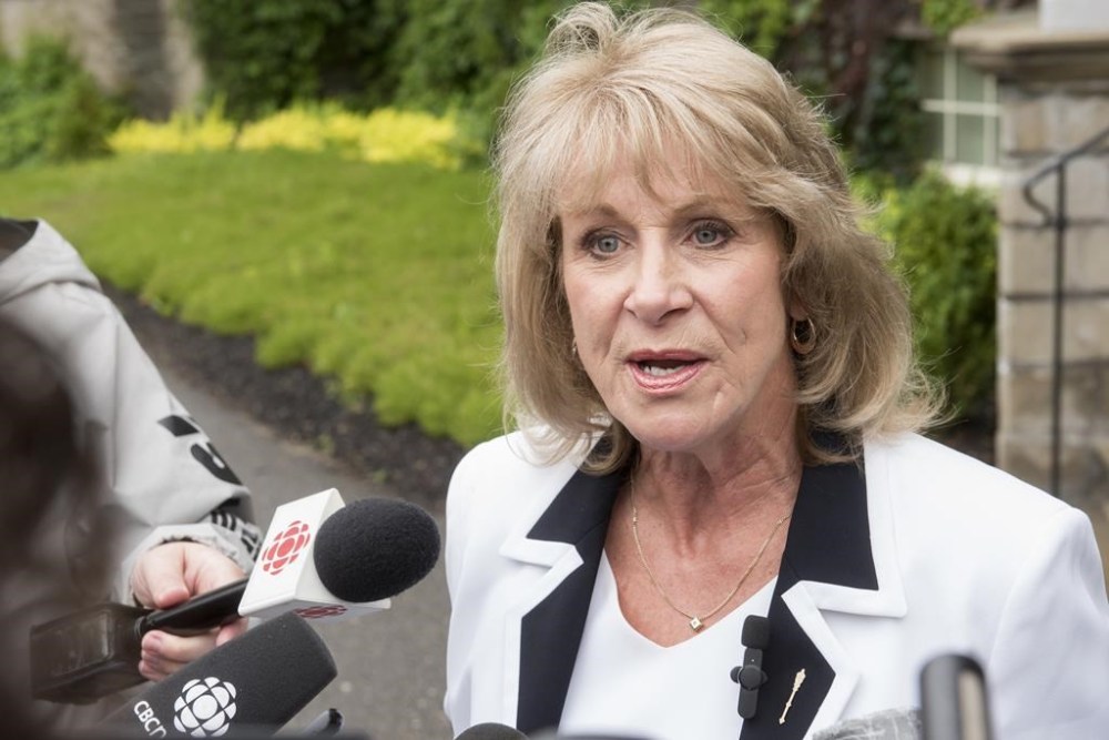 Sherry Wilson speaks to media outside Government House following a cabinet shuffle, in Fredericton, Tuesday, June 27, 2023. A New Brunswick Progressive candidate is facing calls to withdraw from the election after she drew a line between the province's policy on gender identity and sexual orientation for students and the legacy of residential schools. THE CANADIAN PRESS/Stephen MacGillivray