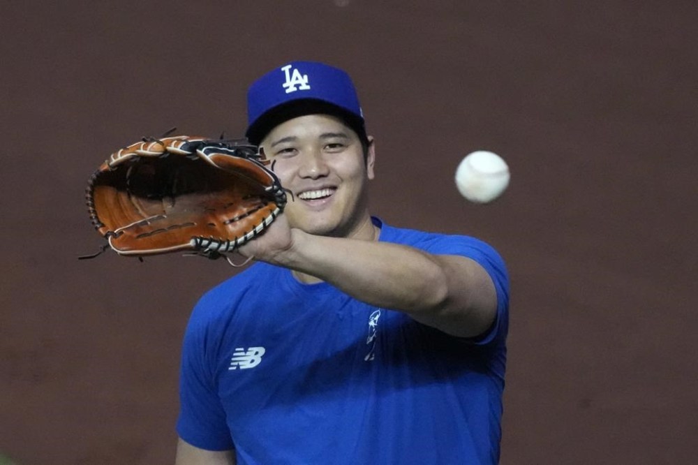 FILE - Los Angeles Dodgers' Shohei Ohtani, of Japan, warms up before the start of a baseball game against the Miami Marlins, Wednesday, Sept. 18, 2024, in Miami. (AP Photo/Wilfredo Lee, File)