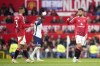 Manchester United's Bruno Fernandes, right, throws a captain armband to Manchester United's Noussair Mazraoui during the English Premier League soccer match between Manchester United and Tottenham Hotspur at Old Trafford stadium in Manchester, England, Sunday, Sept. 29, 2024. (AP Photo/Dave Thompson)