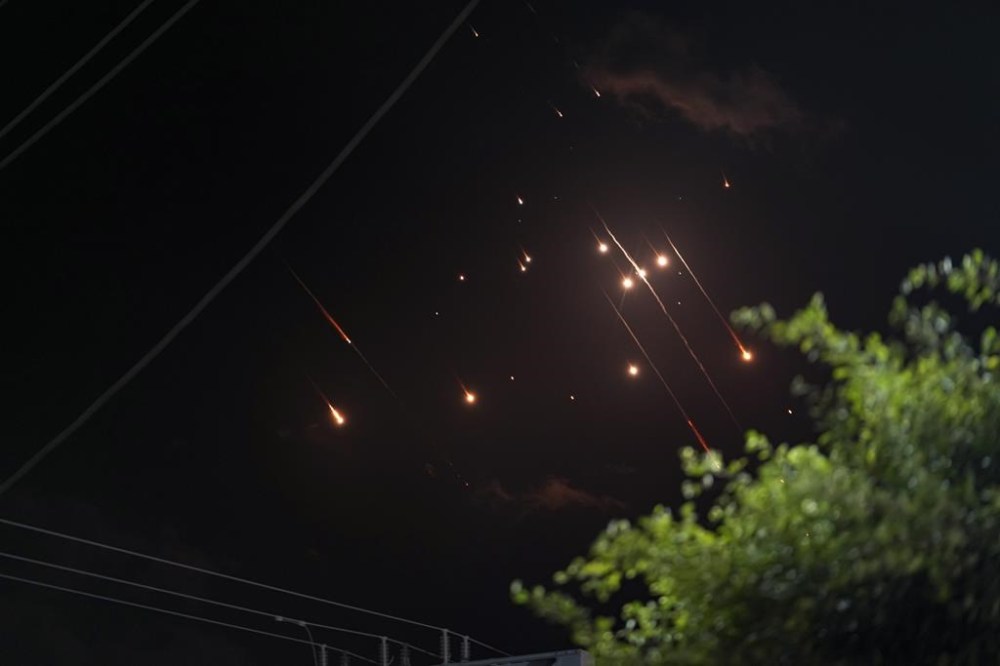 Missiles launched from Iran towards Israel streak across the night sky as seen from Deir al-Balah, Gaza Strip, Tuesday, Oct. 1, 2024. (AP Photo/Abdel Kareem Hana)