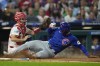 Chicago Cubs' Seiya Suzuki, right, scores past Philadelphia Phillies catcher Garrett Stubbs on a single by Cody Bellinger during the second inning of a baseball game, Tuesday, Sept. 24, 2024, in Philadelphia. (AP Photo/Matt Slocum)