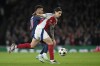 Arsenal's Riccardo Calafiori vies for the ball with PSG's Desire Doue, left, during a Champions League opening phase soccer match between Arsenal FC and Paris Saint-Germain at Arsenal stadium in London, England, Tuesday, Oct. 1, 2024. (AP Photo/Alastair Grant)