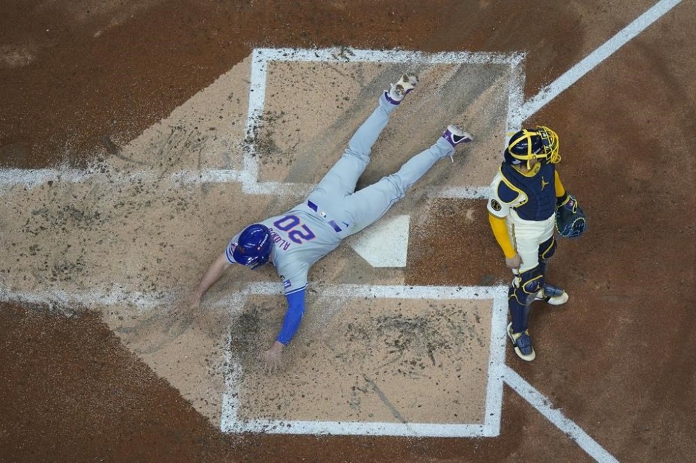 New York Mets' Pete Alonso scores past Milwaukee Brewers catcher William Contreras during the second inning of Game 2 of a National League wild card baseball game Tuesday, Oct. 1, 2024, in Milwaukee. Alonso scored on a triplke by Jesse Winker. (AP Photo/Morry Gash)