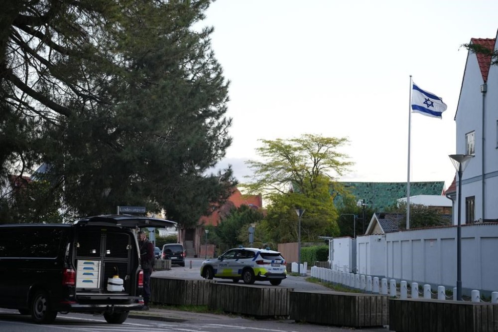 A police vehicle is seen near the Israeli embassy in Copenhagen, as police investigate two explosions near the site, on Wednesday, Oct. 2, 2024. (Emil Helms/Ritzau Scanpix via AP)