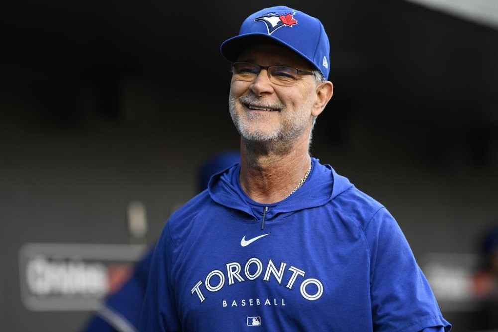 FILE - Toronto Blue Jays bench coach and offensive coordinator Don Mattingly (23) smiles in the dugout before a baseball game against the Baltimore Orioles, May 13, 2024, in Baltimore. (AP Photo/Nick Wass, File)