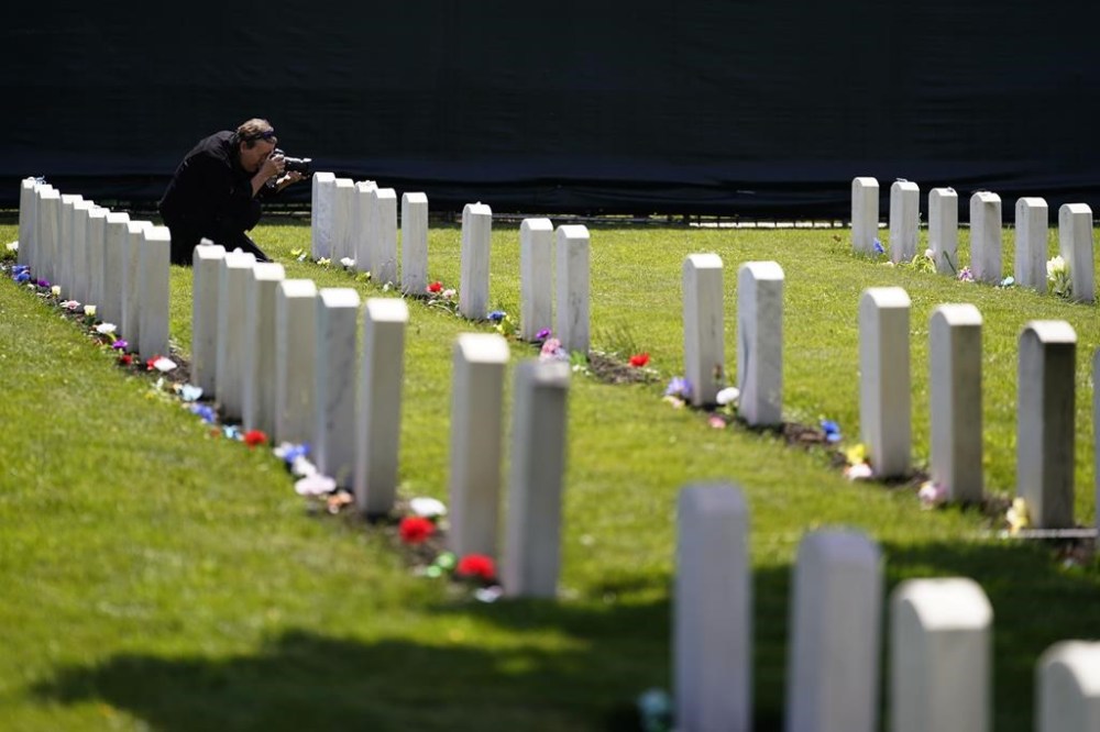 FILE - A member of the media photographs headstones at the cemetery of the U.S. Army's Carlisle Barracks, June 10, 2022, in Carlisle, Pa. (AP Photo/Matt Slocum, File)