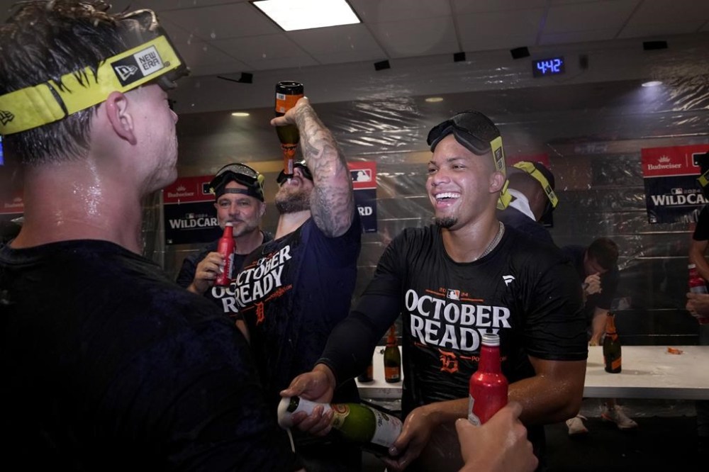 Detroit Tigers' Wenceel Perez, right, celebrates with the team in the clubhouse after defeating the Houston Astros in Game 2 to clinch the AL Wild Card baseball series, Wednesday, Oct. 2, 2024, in Houston. (AP Photo/Kevin M. Cox)