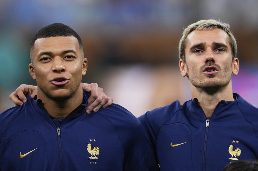 FILE - France's Kylian Mbappe, left, and Antoine Griezmann sing their national anthem before the World Cup final soccer match between Argentina and France at the Lusail Stadium in Lusail, Qatar, Sunday, Dec.18, 2022. (AP Photo/Manu Fernandez, File)