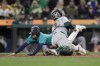 Seattle Mariners' Leo Rivas scores as Oakland Athletics catcher Shea Langeliers reaches to tag during the tenth inning in a baseball game, Saturday, Sept. 28, 2024, in Seattle. The Mariners won 7-6. (AP Photo/John Froschauer)