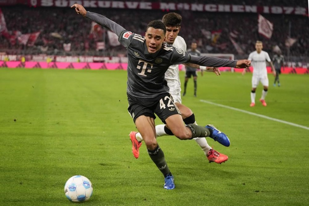 Bayern's Jamal Musiala, left, and Leverkusen's Piero Hincapie vie for the ball during the Bundesliga soccer match between Bayern Munich and Leverkusen at the Allianz Arena in Munich, Germany, Saturday, Sept. 28, 2024. (AP Photo/Matthias Schrader)