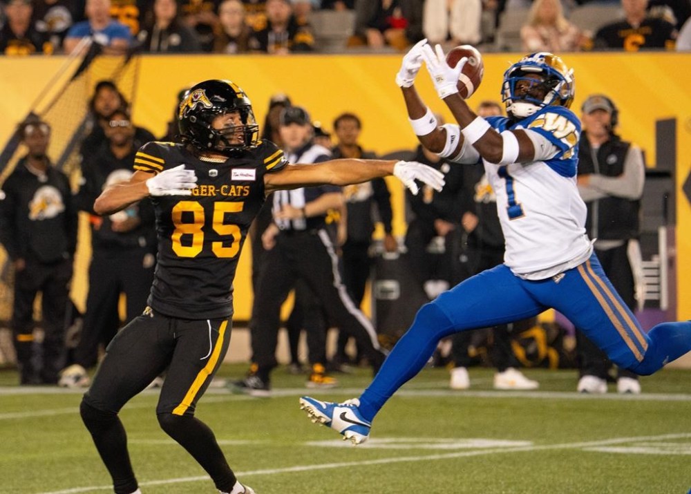 Winnipeg Blue Bombers defensive back Deatrick Nichols (1) intercepts a pass intended for Hamilton Tiger-Cats wide receiver Kiondre Smith (85) during first half CFL football game action in Hamilton, Ont. on Friday, October 4, 2024. THE CANADIAN PRESS/Peter Power