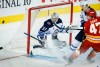 Winnipeg Jets' goalie Connor Hellebuyck, left, guards the net as Calgary Flames' Connor Zary, right, is checked by Haydn Fleury during third period NHL pre-season hockey action in Calgary on Friday, Oct. 4, 2024.THE CANADIAN PRESS/Jeff McIntosh