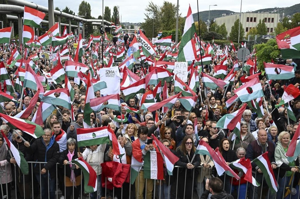 Participants wave national flags during a demonstration organised by the Hungarian opposition Tisza Party against public media at the MTVA headquarters in Budapest, Hungary, Saturday, Oct. 5, 2024. (Szilard Koszticsak/MTI via AP)