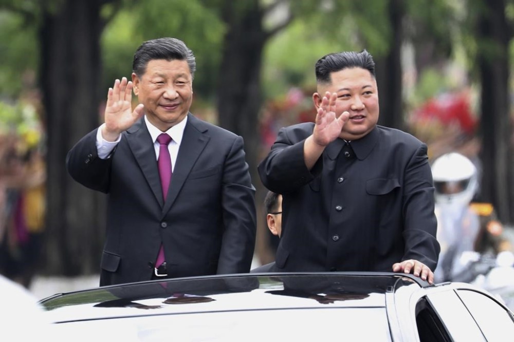 FILE - In this photo released by China's Xinhua News Agency, visiting Chinese President Xi Jinping, left, and North Korean leader Kim Jong Un wave from an open top limousine as they travel along a street in Pyongyang, North Korea, on June 20, 2019. (Ju Peng/Xinhua via AP, File)