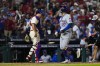New York Mets' Mark Vientos celebrate past Philadelphia Phillies catcher J.T. Realmuto after hitting a two-run home run against Phillies pitcher Matt Strahm during the ninth inning of Game 2 of a baseball NL Division Series, Sunday, Oct. 6, 2024, in Philadelphia. (AP Photo/Matt Slocum)