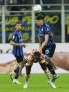 Inter Milan's Alessandro Bastoni, top, heads the ball over Torino's Duvan Zapata during the Serie A soccer match between Inter Milan and Torino at the San Siro Stadium, in Milan, Italy, Saturday, Oct. 5, 2024. (AP Photo/Antonio Calanni)