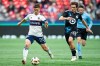 Vancouver Whitecaps' Ryan Gauld (25) and Minnesota United's Will Trapp (20) vie for the ball during the second half of an MLS soccer match in Vancouver, B.C., Saturday, Oct. 5, 2024. THE CANADIAN PRESS/Ethan Cairns