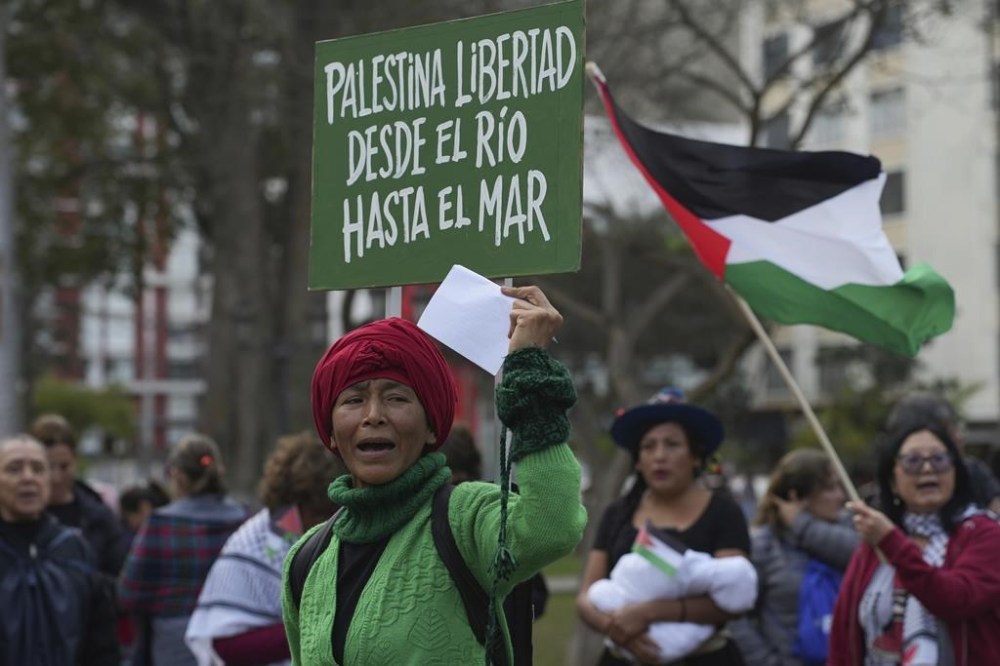 A pro-Palestinian demonstrator holds a sign that reads in Spanish,