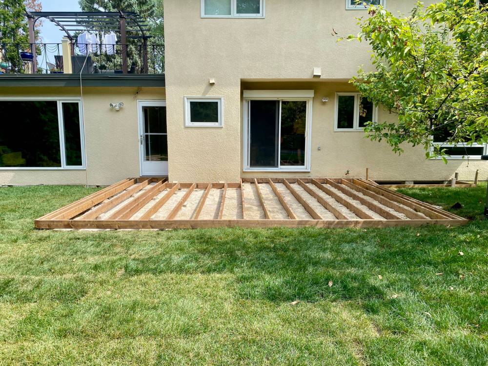 Once the deck footprint was prepped with three-quarter down gravel, 2x6 joists are aligned at 16 inches on-centre atop small concrete pads below every joist.