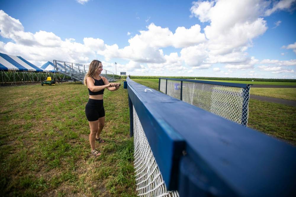 MIKAELA MACKENZIE / FREE PRESS
Melanie Matsyk-Gardiner touches up the paint on the
fences in preparation for the fundraising tournament.