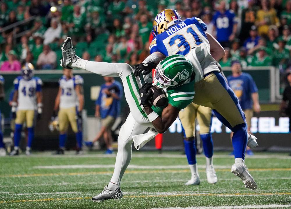 Heywood Yu / THE CANADIAN PRESS
Bombers defensive back Evan Holm (right) lowers the boom on Roughriders receiver Samuel Emilus on Sunday during the Labour Day Classic in Regina.