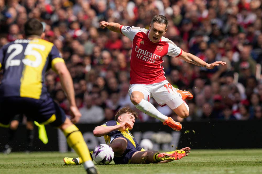 Arsenal’s Leandro Trossard, top, challenges for the ball with Bournemouth’s Alex Scott during the English Premier League soccer match between Arsenal and Bournemouth at Emirates Stadium in London, England, Saturday, May 4, 2024. (AP Photo/Frank Augstein)