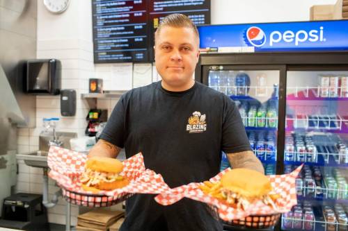 BROOK JONES / FREE PRESS
                                Winnipegger Eric Saniuk, 30, owner of Blazing Chicken Shack, serves a Queen City Buffalo Sando and a Music City Nashville Sando at his restuarant at 392 Graham Ave., in Winnipeg, Man., Monday, Sept. 16, 2024. Saniuk hosted a grand opening Friday, Sept. 13, 2024.