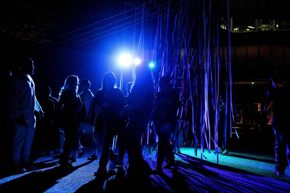 MIKE SUDOMA / FREE PRESS
Nuit Blanche attendees walk through the lit-up streamers outside of the Canadian Museum for Human Rights Saturday night as part of Jaimie Issac’s exhibit “Nibi.”