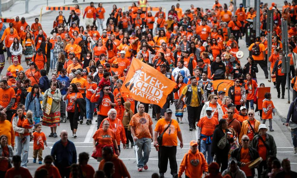 JOHN WOODS / FREE PRESS
People gather for Truth And Reconciliation Day, also known as Orange Shirt Day in Manitoba, as they walk down York Avenue in Winnipeg Monday.