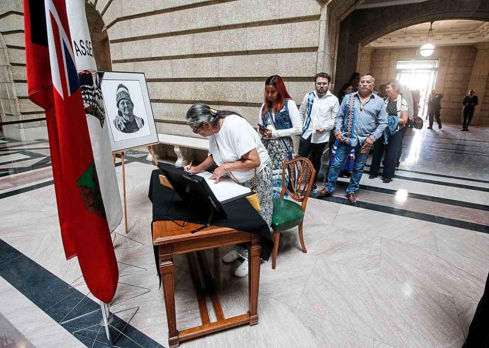 People sign a memorial book for Grand Chief Cathy Merrick. (John Woods / The Canadian Press)