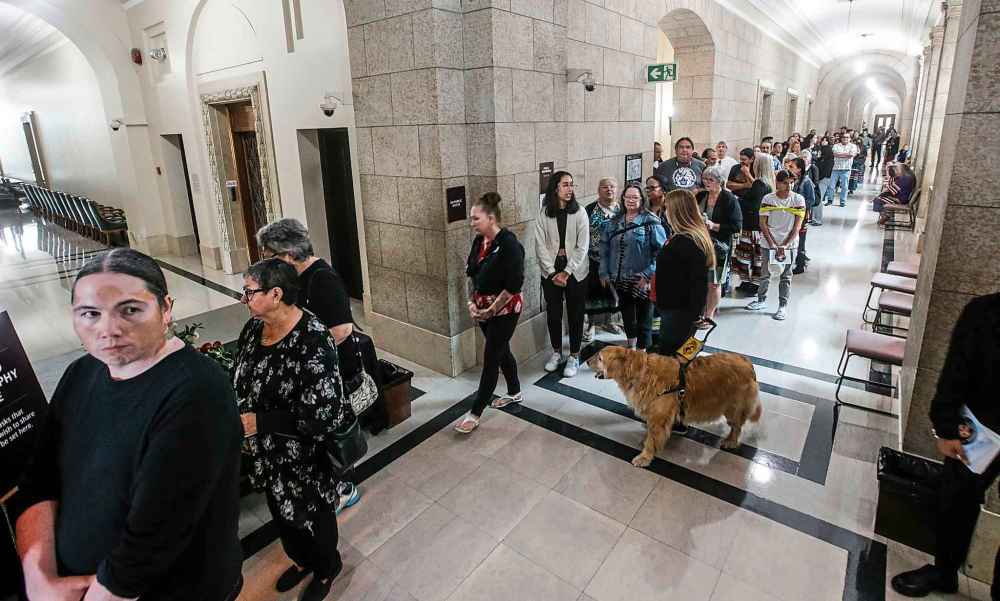 People lineup to sign a memorial book and to view the body of Grand Chief Cathy Merrick who is lying in state at the legislature in Winnipeg on Wednesday. (John Woods / The Canadian Press)