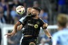 Sporting Kansas City defender Joaquin Fernandez, back, and Los Angeles FC attacker Olivier Giroud battle for the ball during the first half of an MLS soccer match Saturday, Oct. 5, 2024, in Kansas City, Kan. (AP Photo/Charlie Riedel)