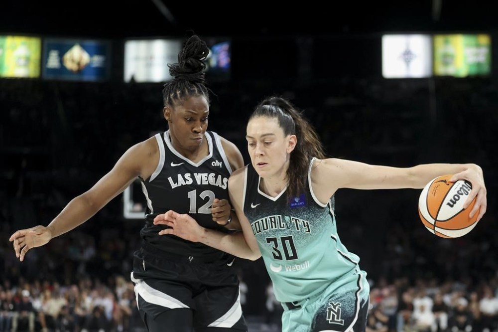 New York Liberty forward Breanna Stewart (30) drives past Las Vegas Aces guard Chelsea Gray (12) during the second half of a WNBA Semifinal basketball game, Sunday, Oct. 6, 2024, in Las Vegas. (AP Photo/Ian Maule)