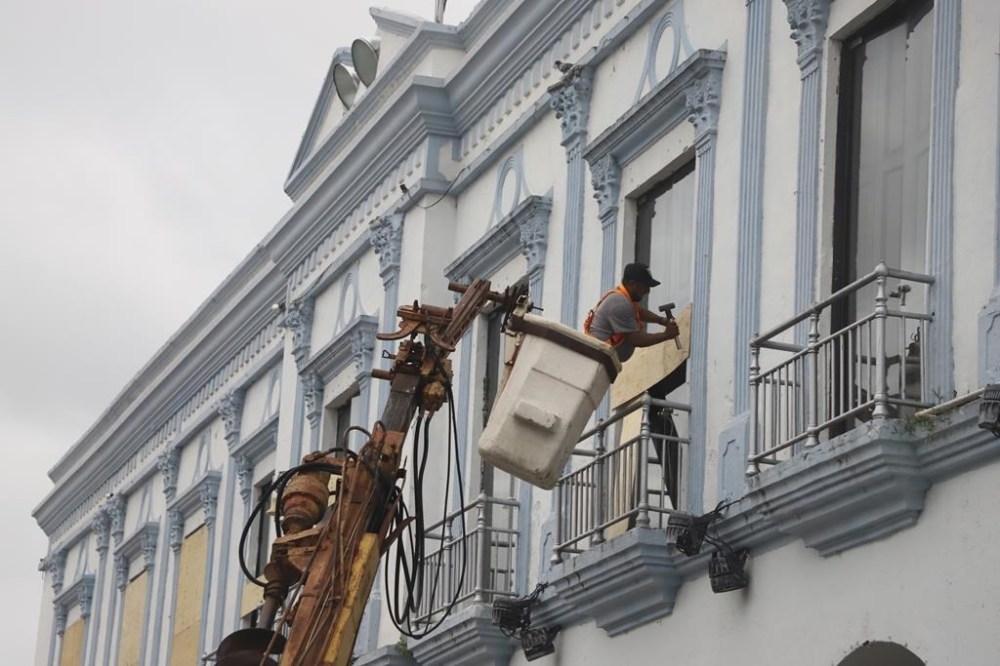 A man boards up a government building to protect it from Hurricane Milton, in Progreso, Yucatan state, Mexico, Monday, Oct. 7, 2024. (AP Photo/Martin Zetina)