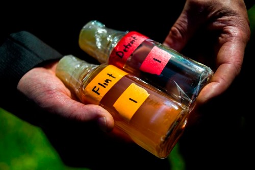 FILE - Virginia Tech professor Marc Edwards shows the difference in water quality between Detroit and Flint after testing, giving evidence after more than 270 samples were sent in from Flint that show high levels of lead during a news conference on Sept. 15, 2015, in downtown Flint, Mich. (Jake May/The Flint Journal via AP, File)