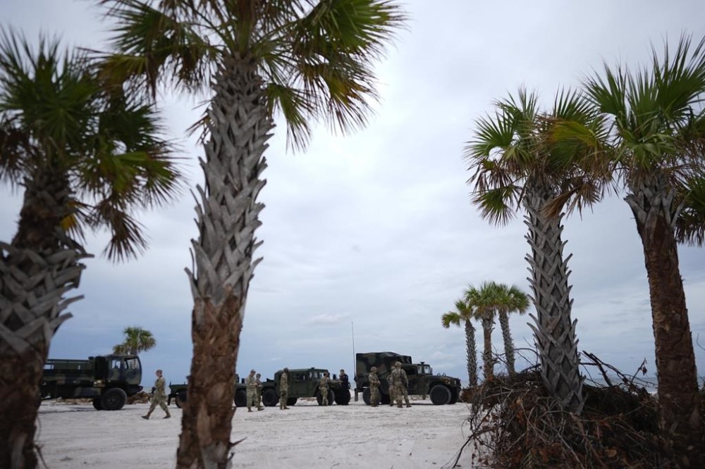 Members of the Florida Army National Guard stage on a beach as they prepare for the arrival of Hurricane Milton, in Bradenton Beach on Anna Maria Island, Fla., Tuesday, Oct. 8, 2024. (AP Photo/Rebecca Blackwell)