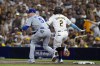 San Diego Padres' Xander Bogaerts, right, is safe with an infield single past Los Angeles Dodgers first baseman Freddie Freeman during the second inning in Game 3 of a baseball NL Division Series Tuesday, Oct. 8, 2024, in San Diego. (AP Photo/Gregory Bull)