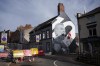 A mural of Wrexham soccer club's star striker Paul Mullin is visible in the center of Wrexham, Wales, Monday, Oct. 7, 2024. (AP Photo/Jon Super)