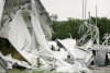 FILE - A fire fighter, center, stands surrounded by the collapsed canopy that covered the Dallas Cowboys indoor practice facility in Irving, Texas, on May 2, 2009. (AP Photo/Tony Gutierrez, File)