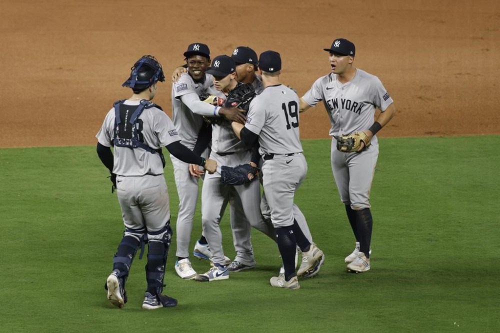 Members of the New York Yankees celebrate a 3-1 victory over the Kansas City Royals in Game 4 of an American League Division baseball playoff series Thursday, Oct. 10, 2024, in Kansas City, Mo. (AP Photo/Colin Braley)