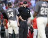 Home plate umpire Nic Lentz, center, looks on as Washington Nationals' Ildemaro Vargas (14) and Philadelphia Phillies' Bryce Harper, center back, and others come onto the field as dugouts cleared during the eighth inning of a baseball game, Saturday, Sept. 28, 2024, in Washington. (AP Photo/Nick Wass)