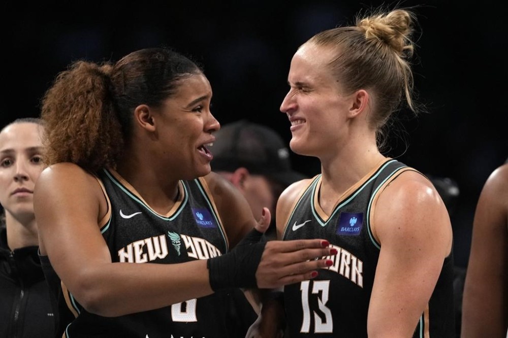 New York Liberty's Nyara Sabally, front left, and Leonie Fiebich, right, react after defeating the Minnesota Lynx in Game 2 of a WNBA basketball final playoff series, Sunday, Oct. 13, 2024, in New York. (AP Photo/Pamela Smith)