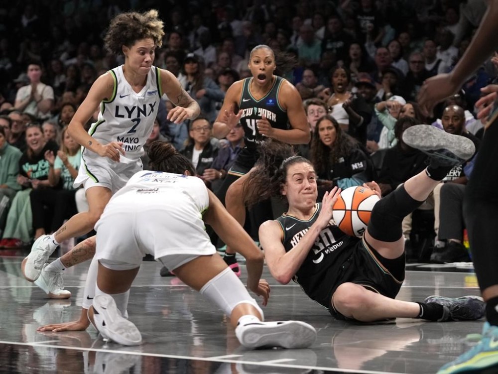 New York Liberty's Breanna Stewart, right, and Minnesota Lynx's Napheesa Collier, front left, fight for the ball during the second half in Game 2 of a WNBA basketball final playoff series, Sunday, Oct. 13, 2024, in New York. (AP Photo/Pamela Smith)