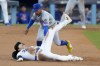Los Angeles Dodgers' Shohei Ohtani steals second base past New York Mets shortstop Francisco Lindor during the second inning in Game 1 of a baseball NL Championship Series, Sunday, Oct. 13, 2024, in Los Angeles. (AP Photo/Mark J. Terrill)