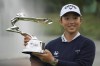 Ruoning Yin of China holds up her trophy for photos after winning the LPGA Shanghai golf tournament at China's Shanghai Qizhong Garden Golf Club, Sunday, Oct. 13, 2024. (AP Photo/Achmad Ibrahim)