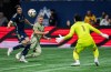 Los Angeles FC's Mateusz Bogusz, centre, scores on Vancouver Whitecaps goalkeeper Yohei Takaoka, right, as Bjorn Inge Utvik, left, defends during the first half of an MLS soccer match in Vancouver, B.C., Sunday, Oct. 13, 2024. THE CANADIAN PRESS/Ethan Cairns